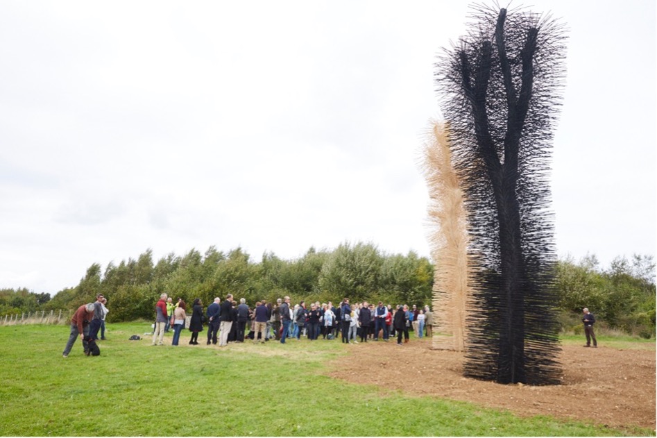 A group of people standing around a treeDescription
          automatically generated with low confidence